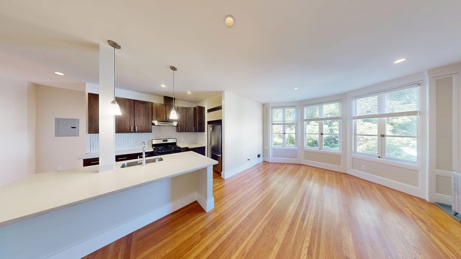A kitchen with wooden floors and white walls.